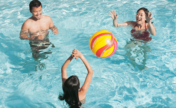 famille jouant au ballon dans la piscine