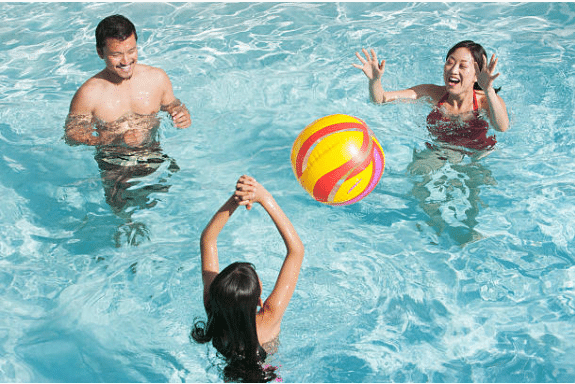 famille jouant au ballon dans la piscine