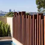 Une piscine entourée de barrières en bois massif design