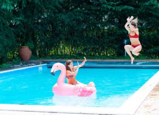 Une maman et sa fille qui s'amusent dans la piscine de leur jardin